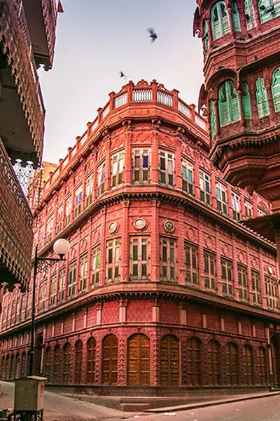 The distinct red and brown facade of traditional havelis in Bikaner, reflecting the rich cultural heritage encountered on the drive from Abu Road.